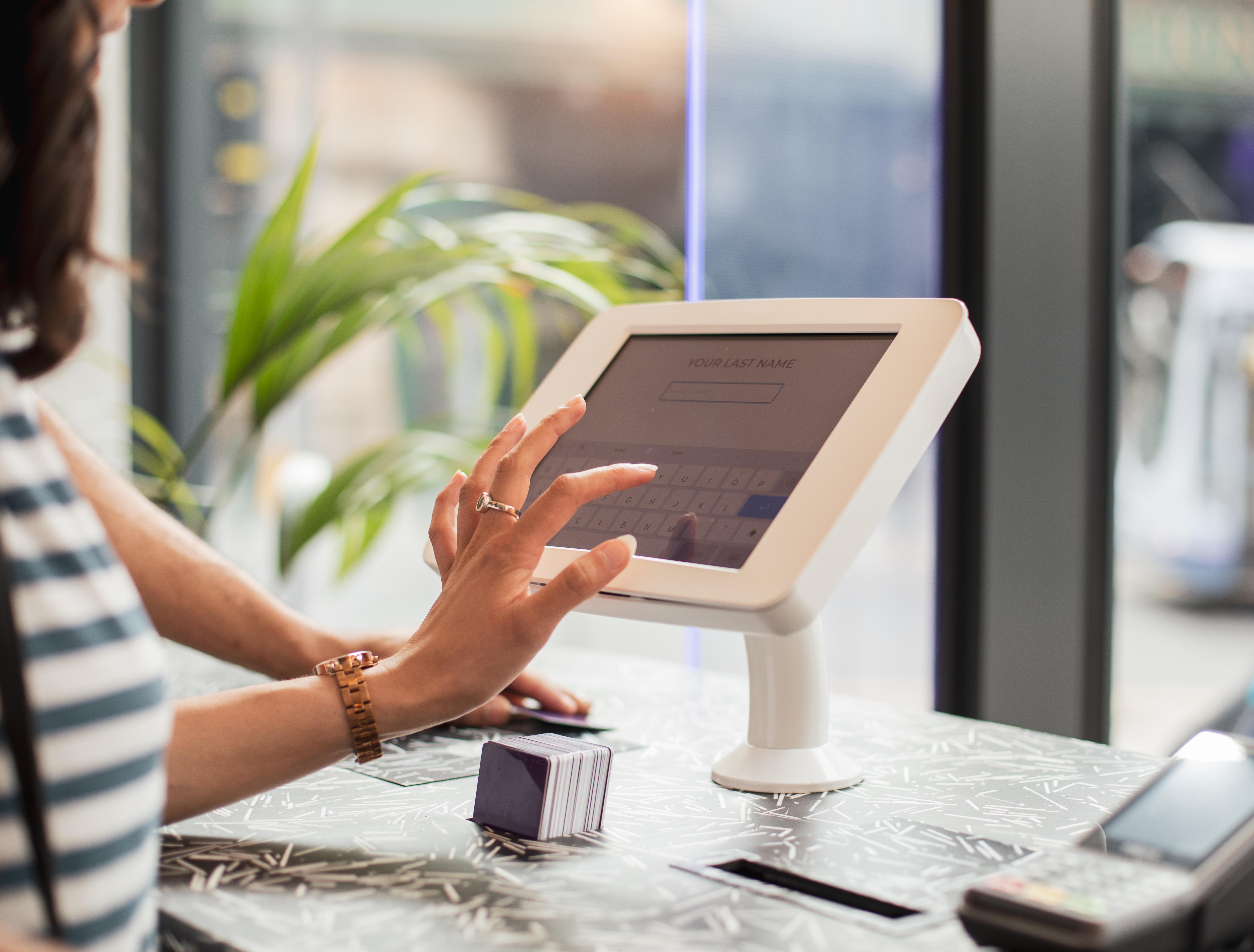 Yotel Glasgow Esterno foto A woman using a tablet to enter her name at a check-in desk