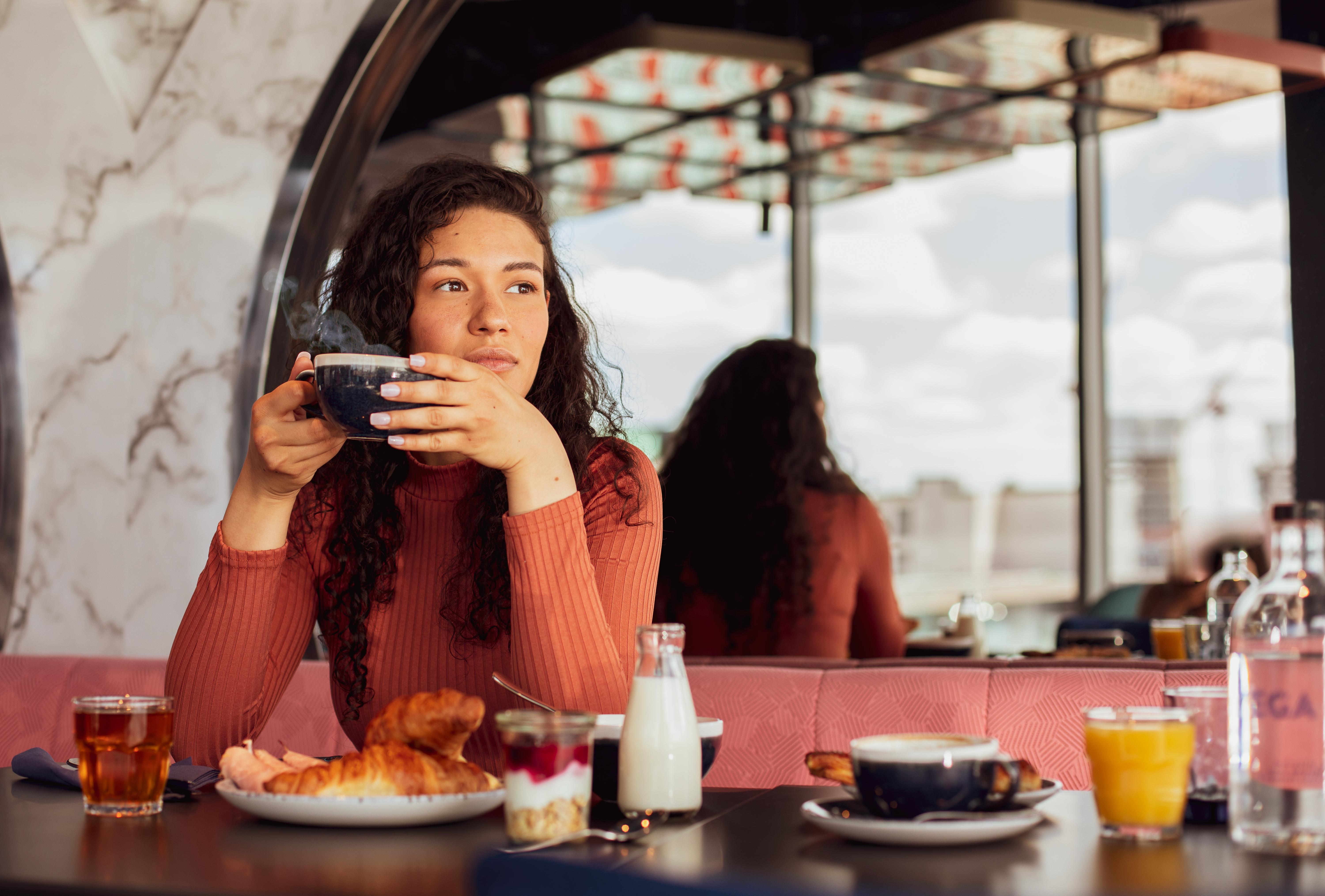 Yotel Glasgow Esterno foto A woman having breakfast at a cafe.
